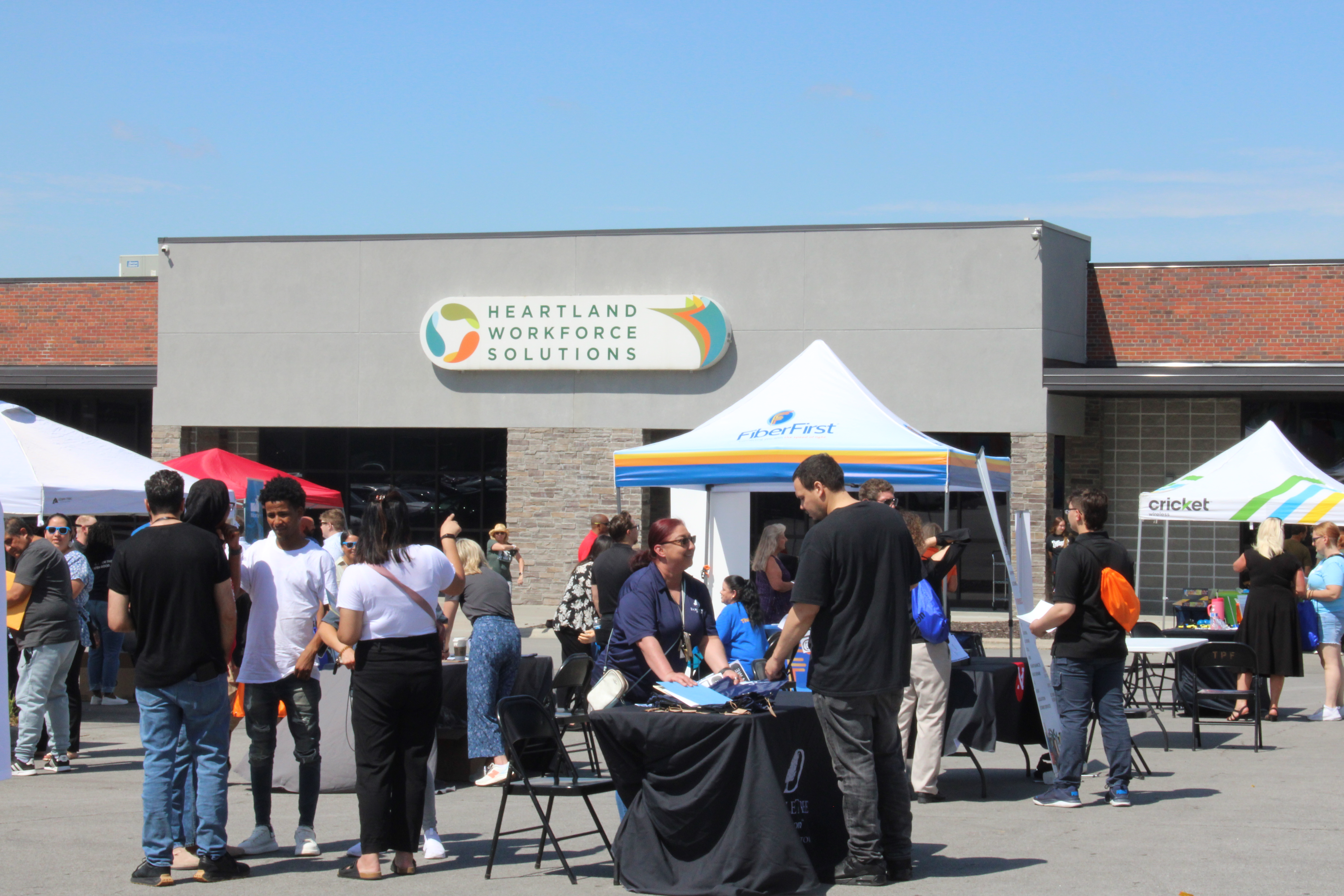 The Ames location during Jobapalooza. Many people are smiling and walking around in the sunshine.